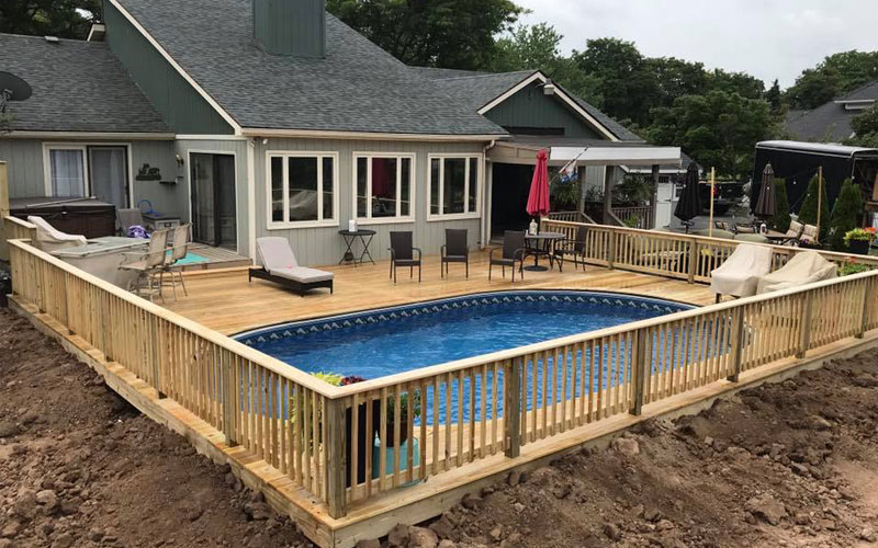 Inground pool with wooden deck and railing